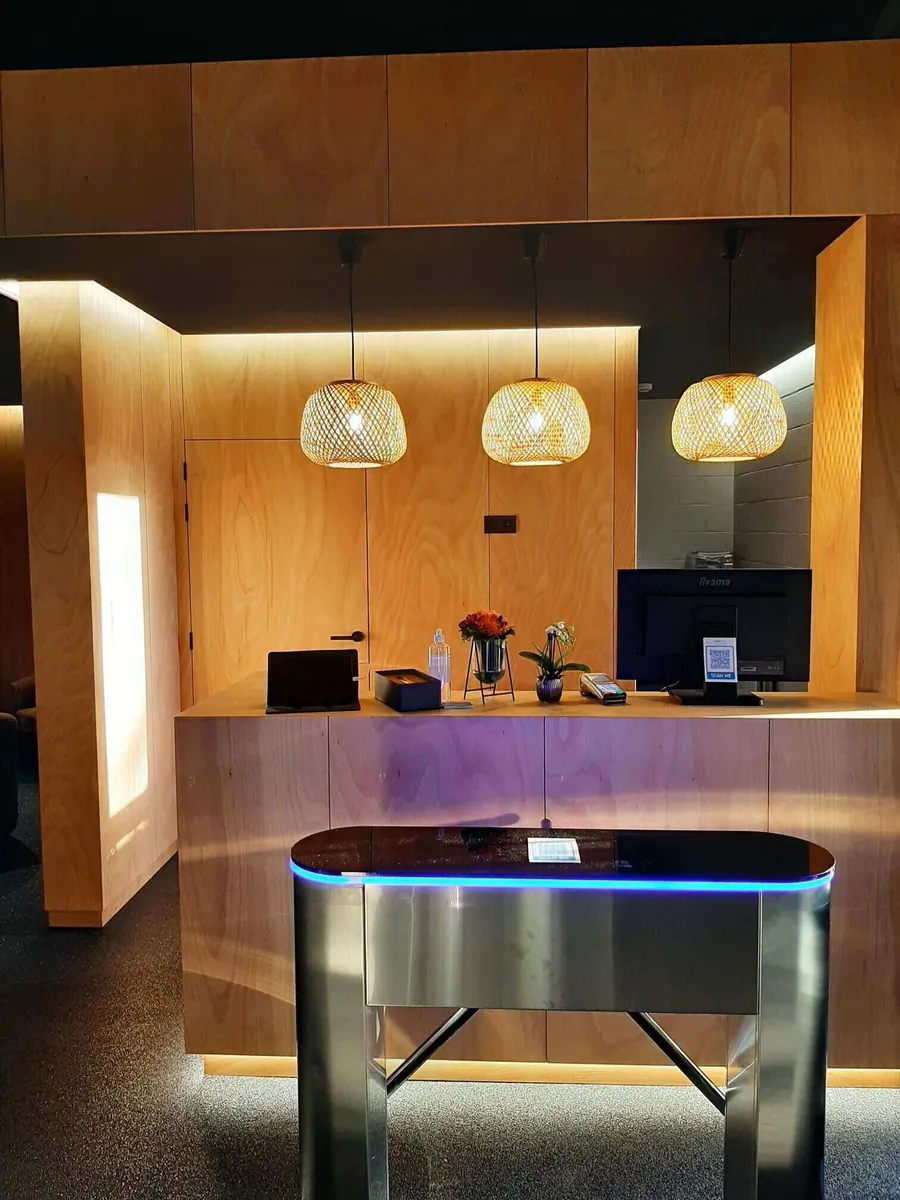 Le comptoir d'accueil en bois clair, éclairé d'un liseré bleu.