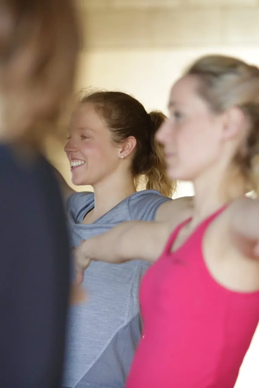Deux participantes souriantes pendant un cours collectif.
