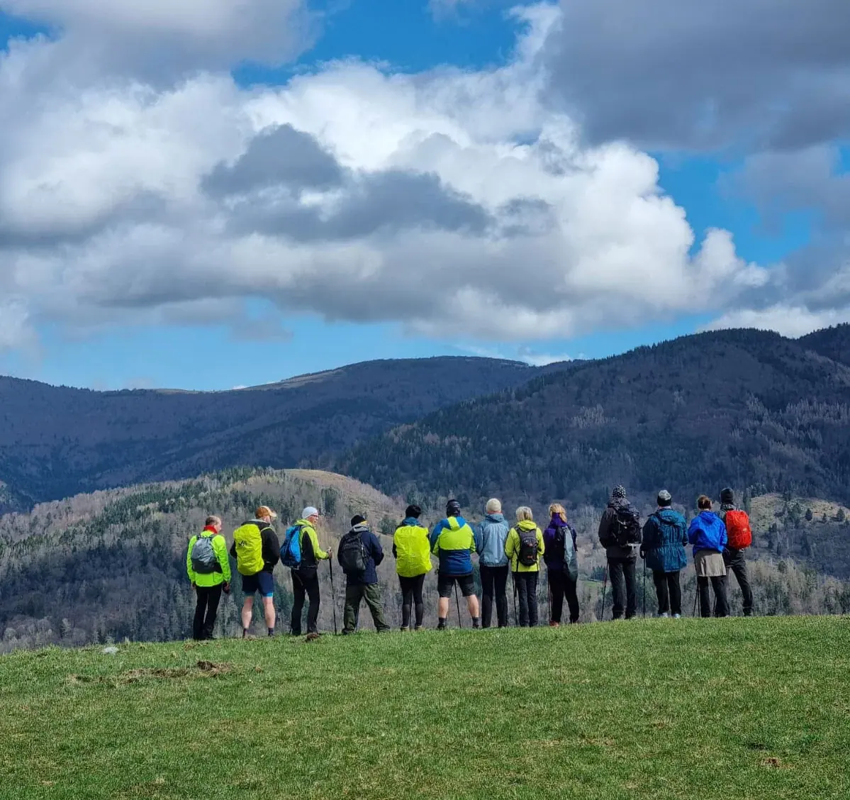 Un groupe de randonneurs en ligne sur une crête, face au panorama.